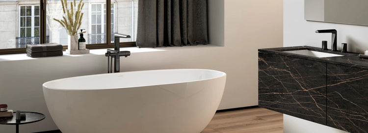 Riobel Parabola floor-mount tub filler in black beside a freestanding bath