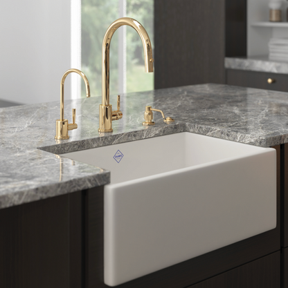 White kitchen sink with gold faucet in a modern kitchen setting